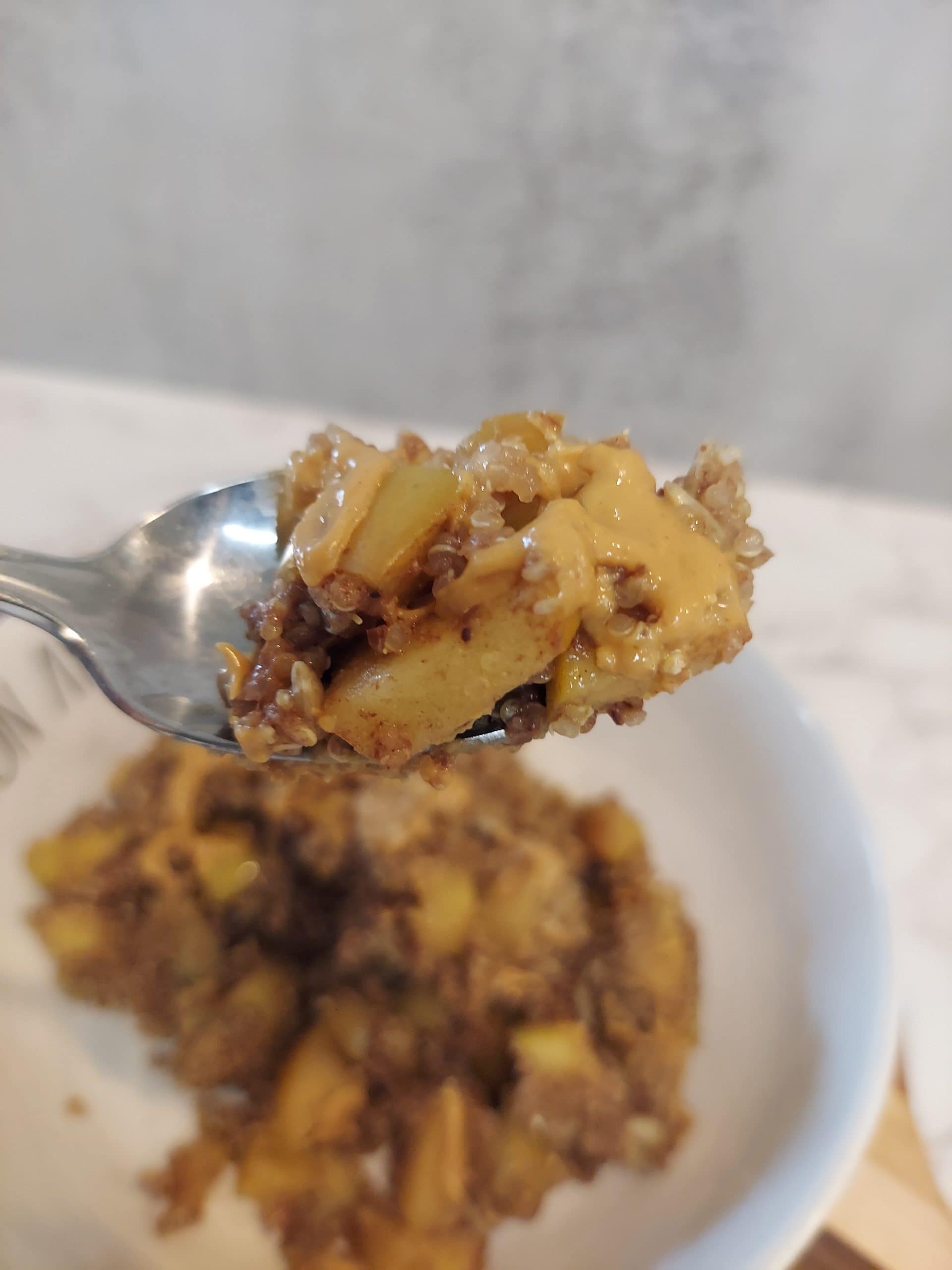 close-up of a forkful of warm quinoa with baked cinnamon apples