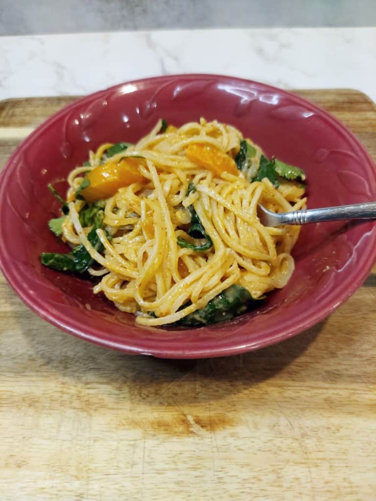 one-pan creamy coconut curry noodles served in a bowl with lime and cilantro
