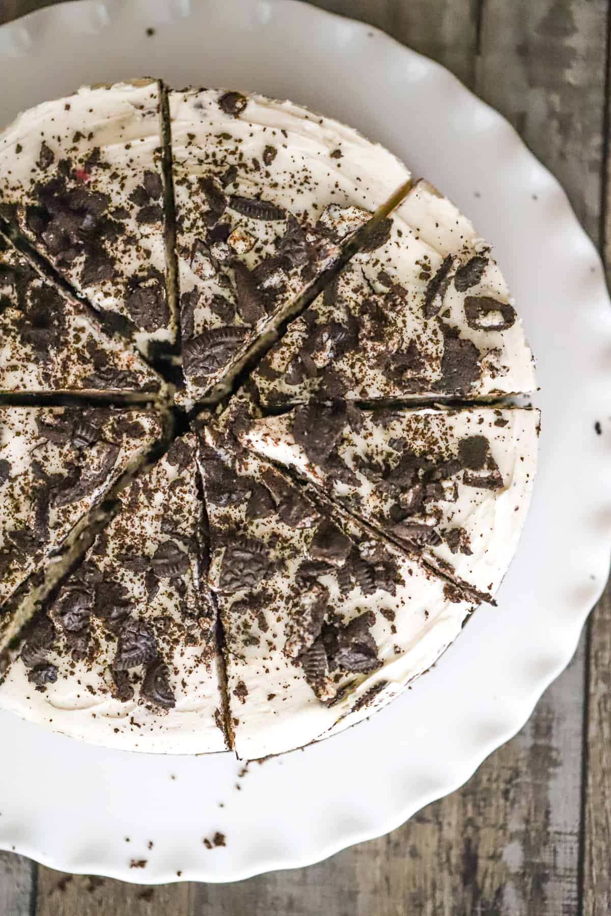 slice of vegan Oreo cheesecake on a plate with cookie crumbs