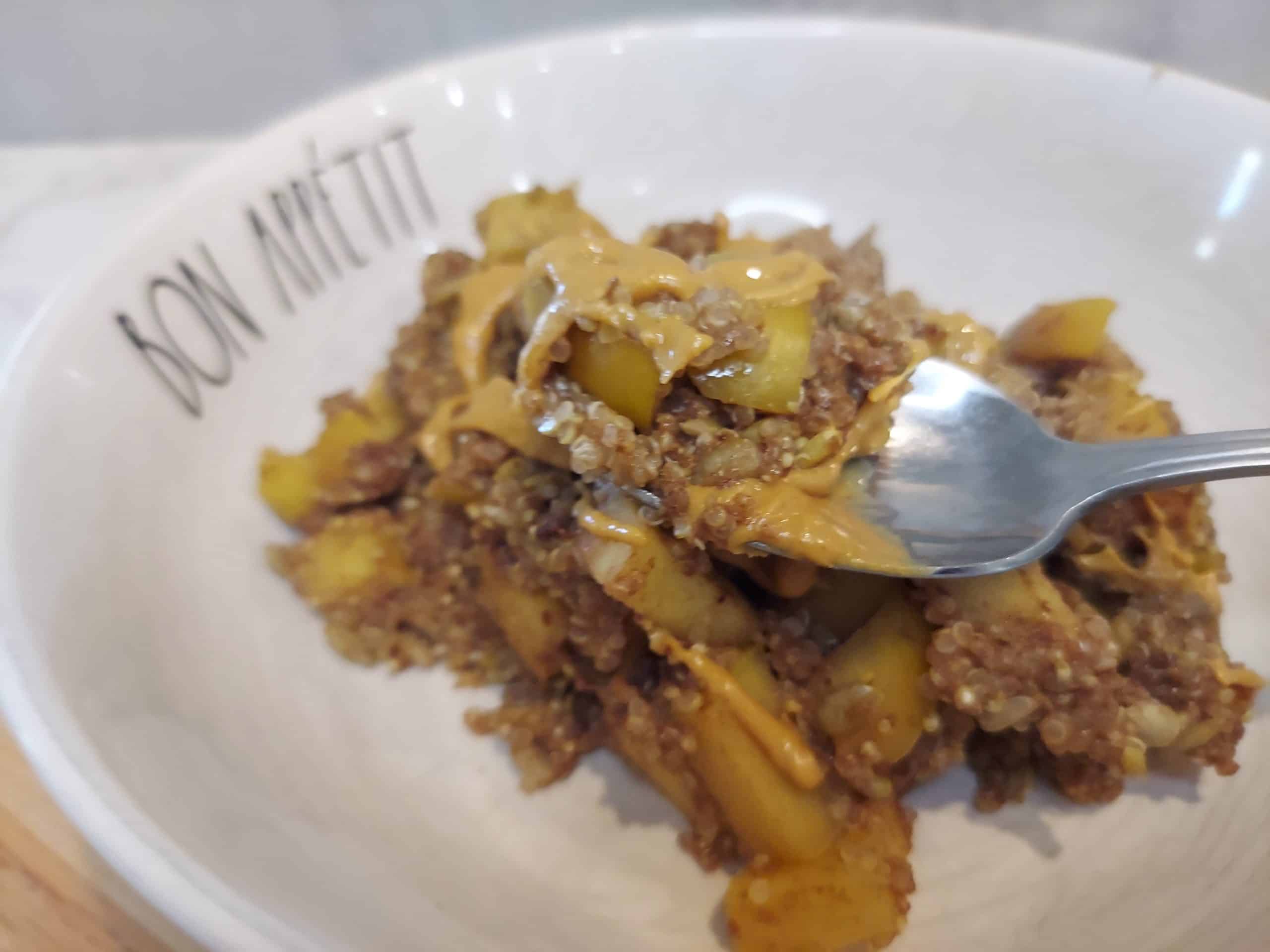 vegan quinoa breakfast bowl with warm apples and peanut butter