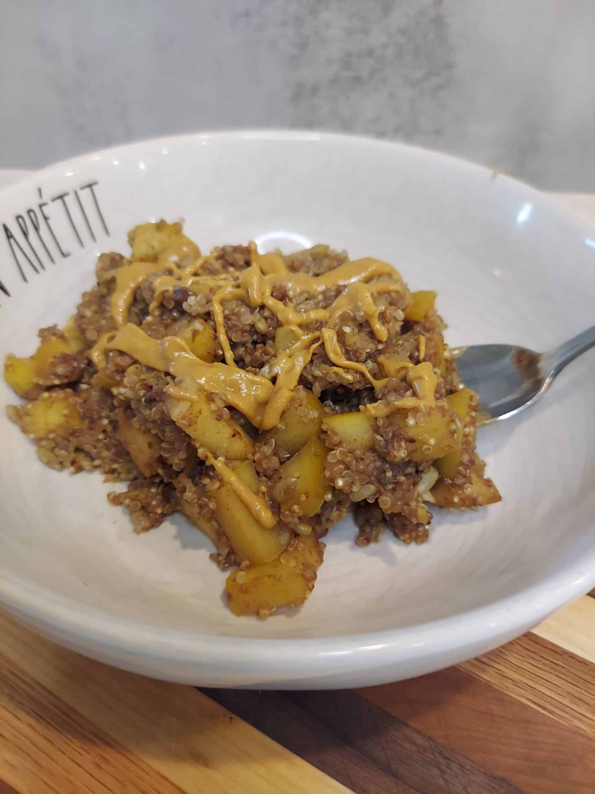 bowl of warm quinoa and apples topped with melted peanut butter