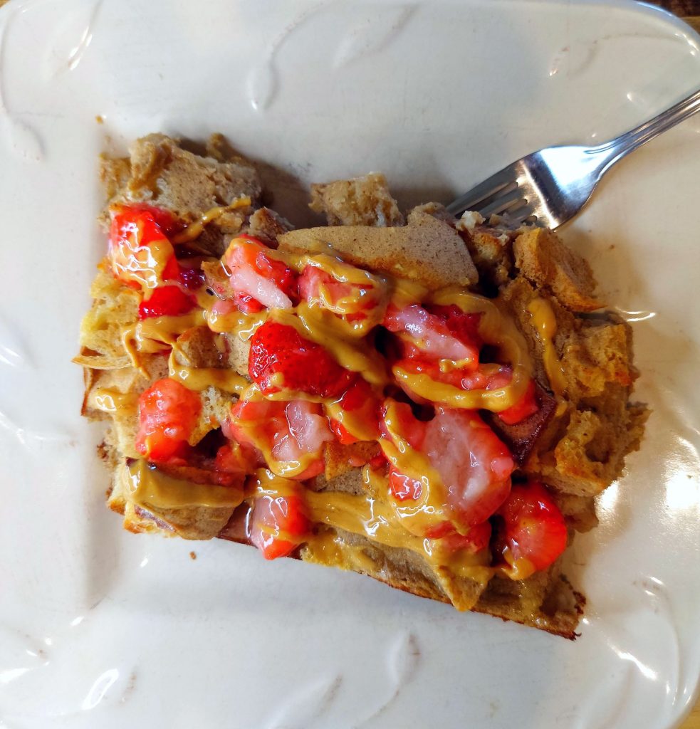 vegan protein french toast served with fresh strawberries and peanut butter drizzle